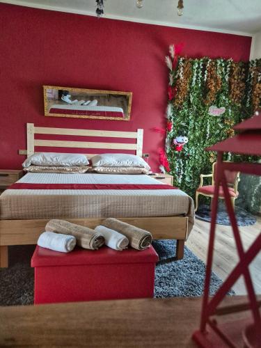 a bedroom with red walls and a bed with towels at Sogni appesi in Valleluce-Cese
