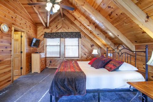 a bedroom with a bed in a wooden cabin at Whisk-A-Way - Hot Tub, Pool Table & Jacuzzi! in Abbeyville