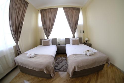 two beds in a room with a window at S&L Boutique Hotel in Tbilisi City