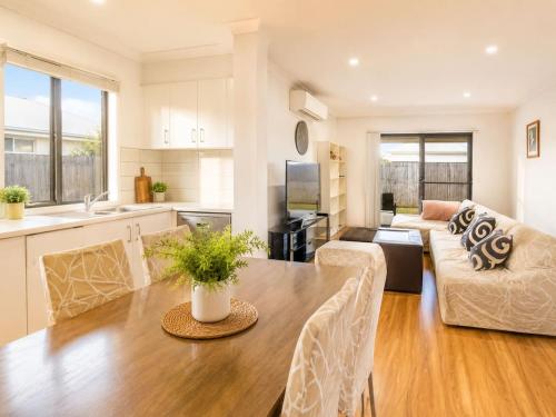 a kitchen and living room with a table and a couch at Spacious 4B Near Logan with Parking in Marsden
