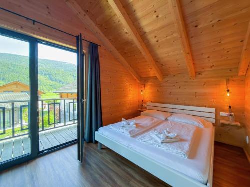 a bedroom with a bed and a large window at Rattendorf 3A in Rattendorf