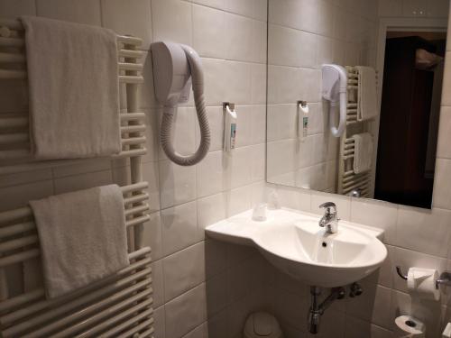 a bathroom with a sink and a mirror and towels at Ibis Brussels Erasmus in Brussels