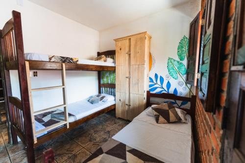 a room with two bunk beds in a house at Cacau Biruta in Itacaré