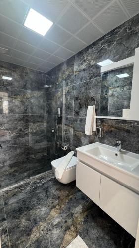 a bathroom with a sink and a toilet and a shower at The Brothers Suite Dalaman in Dalaman