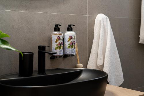 a bathroom with a sink with two bottles on it at PETRA Luxury Villas in Agioi Apostoli