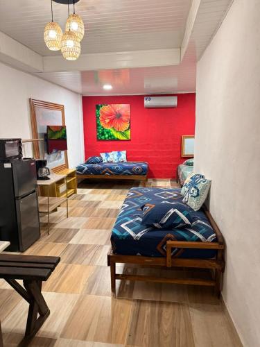 a bedroom with two beds and a red wall at Vicina Maris Beach Lodge in María Chiquita