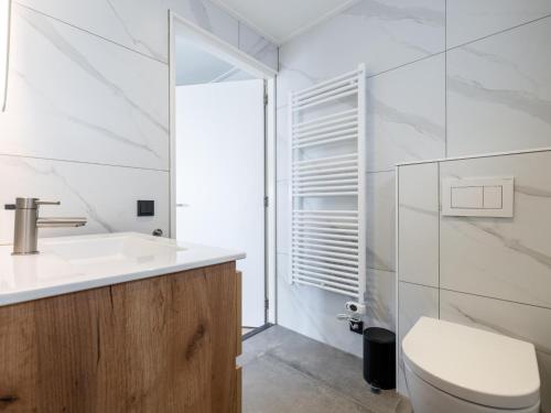 a white bathroom with a sink and a toilet at t Sluisje 8 in Bantega