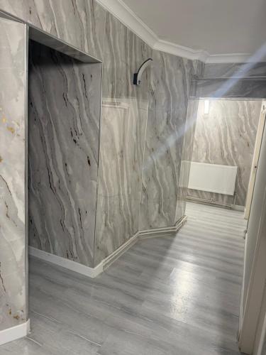a bathroom with a shower with a marble wall at Başkent otel in Mudanya