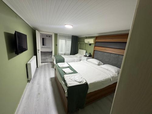 a small room with two beds and a television at Başkent otel in Mudanya