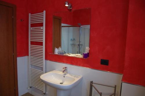 a red bathroom with a sink and a mirror at Agriturismo Casa Villi in Solferino