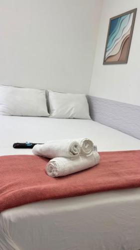 a white towel sitting on top of a bed at Repouso Box in Cabo de Santo Agostinho