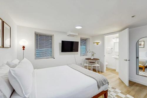 a white bedroom with a large bed and a bathroom at The Gordon Getaway in Seattle