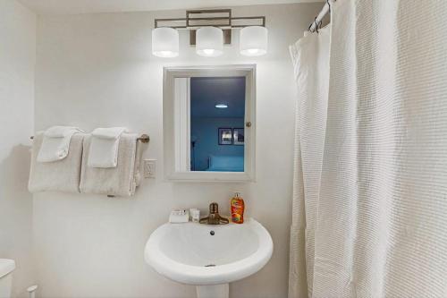 a white bathroom with a sink and a mirror at The Gordon Getaway in Seattle