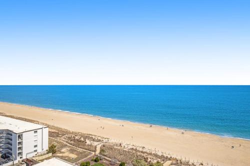 a view of a beach with a building and the ocean at Carousel 1605 in Ocean City