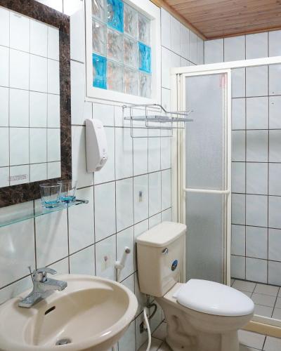 a white bathroom with a toilet and a sink at Hillside Plot Inn in Nanzhuang