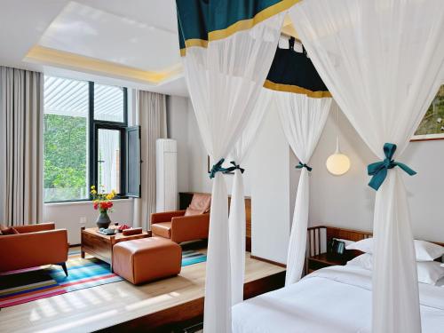 a bedroom with a bed and a living room at Between Trees and Streams in Jiuzhaigou