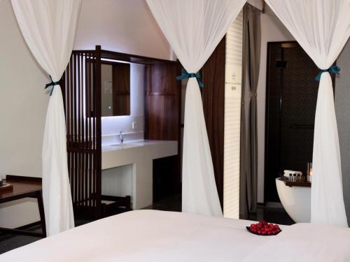 a bedroom with a bed and a bathroom with a sink at Between Trees and Streams in Jiuzhaigou