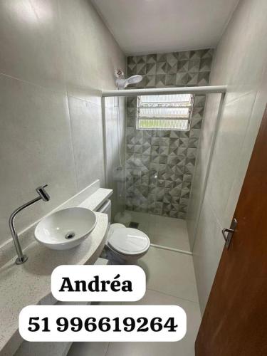 a bathroom with a toilet and a sink and a shower at Canto dos pássaros in Tramandaí