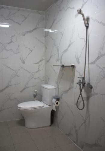 a bathroom with a toilet and a shower at Koregon Hotel in Fort Stotsenburg