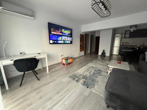 a living room with a couch and a desk and a television at Panoramic Self Check-in Underground Parking in Iaşi