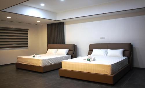 two beds in a room with two bedsitures at Koregon Hotel in Fort Stotsenburg