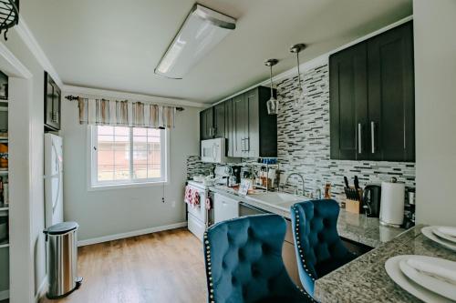 a kitchen with black cabinets and a counter top at The Homestead Luxury Cozy 2BR Apartment in Nacogdoches Near SFA University and Downtown Pet Friendly Business Ready Extended Stays Welcome with Self Check In High Speed WiFi Full Kitchen In Unit Laundry Private Parking and Quiet Comfort in Nacogdoches