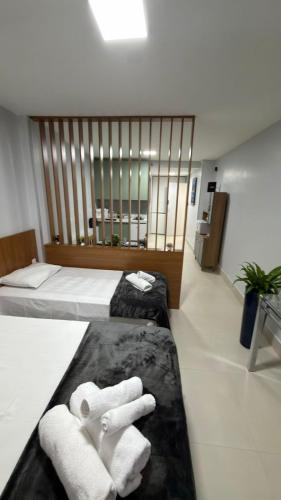 a hotel room with two beds and two towels at Loft centro de Goiânia 1108 in Goiânia