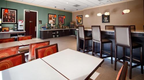 a restaurant with tables and chairs and a bar at Best Western Plus Roswell/Alpharetta in Roswell