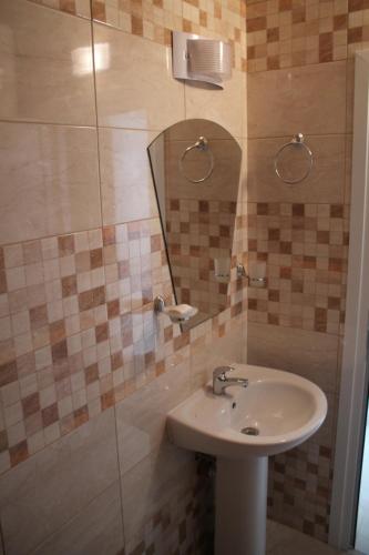 uma casa de banho com um lavatório e um espelho em Tiara Hotel em Dobrich