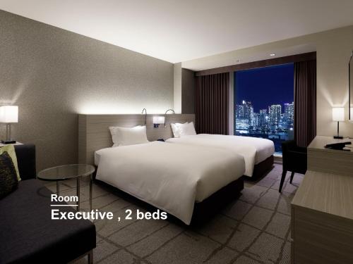 a hotel room with two beds and a window at Mitsui Garden Hotel Ginza Premier in Tokyo