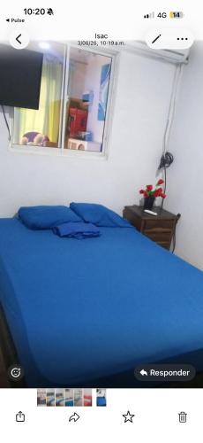a blue bed in a room with a window at El viajero relax in Malambo