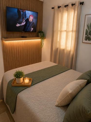 a bedroom with a bed with a flat screen tv at El viajero relax in Malambo