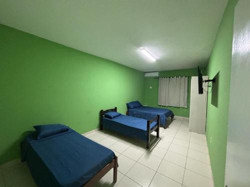 a hospital room with two beds and green walls at Araçagy Casa Mar in São José de Ribamar
