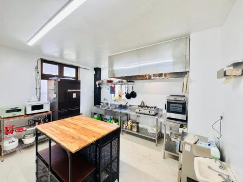 a large kitchen with a wooden table in it at 富士Base御殿場 Station-Side in Gotemba
