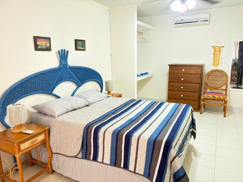 a bedroom with a blue and white bed and a table at Oasis del Mar- Departamento Palma in Progreso