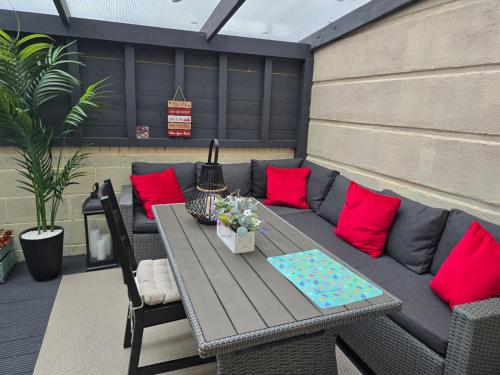 a picnic table with red pillows on a patio at Dreams and Homes in Dublin- Entire home in Hartstown