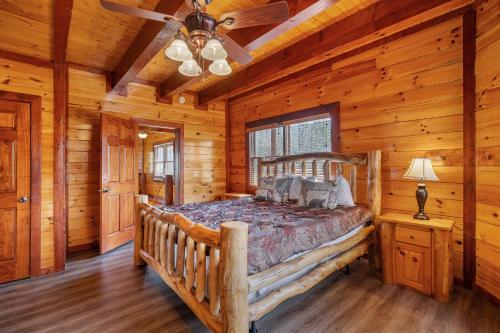 a bedroom with a bed in a log cabin at Cherokee Pool Lodge in Cosby