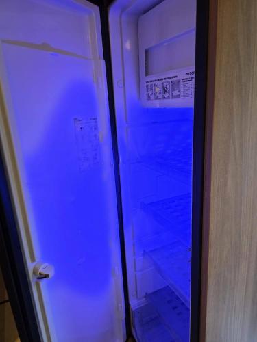 a refrigerator is lit up with blue light at Kościelnik Camp in Kościelnik