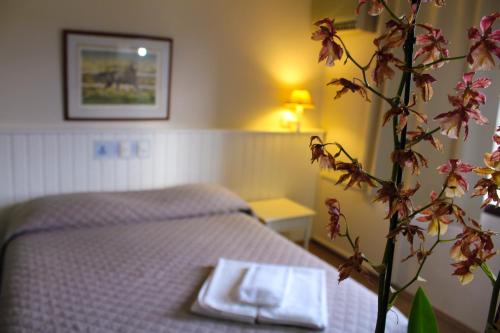 a bedroom with a bed with a table and a plant at Hotel Residence Jaguary in Jaguariúna