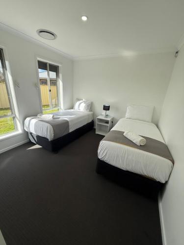 a bedroom with two beds and a window at The Holiday Home Griffith in Griffith