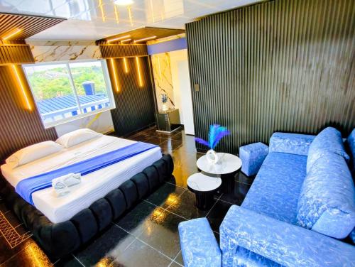 a bedroom with a large bed and blue furniture at Arte Hotel del Quindío in Filandia