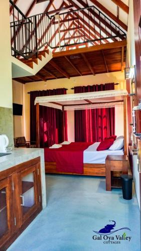 a bedroom with a large bed with red curtains at Gal Oya Valley Cottages in Ampara