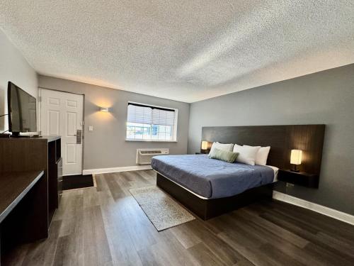 a bedroom with a bed and a flat screen tv at O'Hare Inn & Suites in Schiller Park