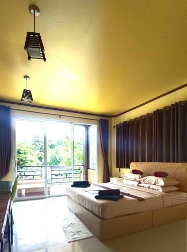 a bedroom with a large bed and a large window at Khao Sok Country Resort in Khao Sok National Park