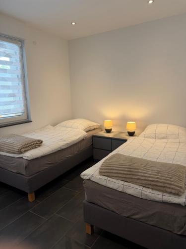 two beds in a room with two lamps on them at RS home CB 1 in Cottbus