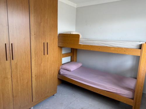 a room with two bunk beds and wooden cabinets at Estrela-do-mar in Serra