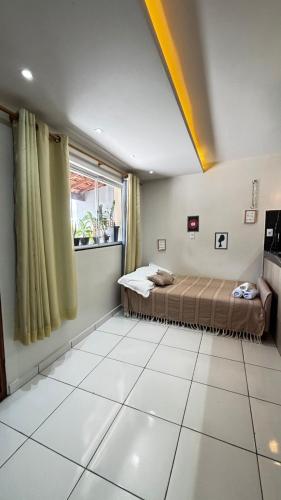 a bedroom with a bed and a large window at Flat Ubuntu in Viçosa do Ceará