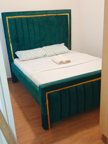 a bed with a green headboard and white mattress at Kitengela prime suites in Kitengela 