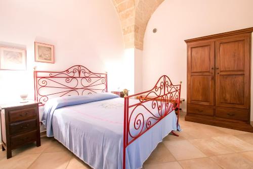 a bedroom with a large bed and a wooden cabinet at Villa Riggia in Nardò