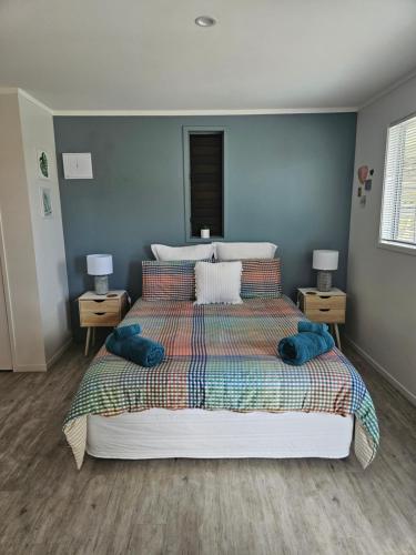 a bedroom with a large bed with blue pillows at Diamond Retreat in Tairua